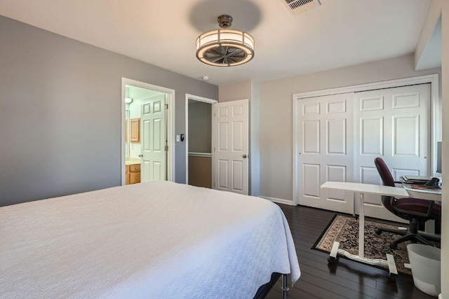6900 E Riverside Dr Unit 6, Austin, TX 78741 - bedroom featuring dark wood-style flooring, a closet, an office area, baseboards, and ensuite bath