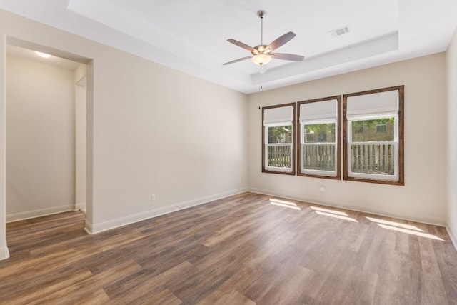 604 Germander Rd, Leander, TX 78641 - unfurnished room with a tray ceiling, wood finished floors, ceiling fan, and baseboards