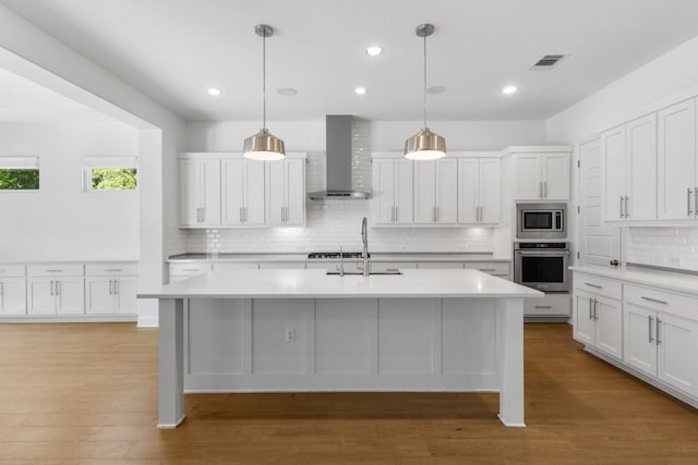 604 Germander Rd, Leander, TX 78641 - kitchen with wall chimney exhaust hood, appliances with stainless steel finishes, a sink, light countertops, and backsplash