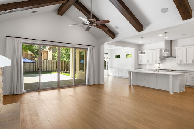 604 Germander Rd, Leander, TX 78641 - unfurnished living room featuring high vaulted ceiling, light wood-style floors, beamed ceiling, a ceiling fan, and recessed lighting