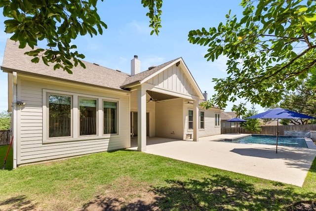 604 Germander Rd, Leander, TX 78641 - back of house featuring board and batten siding, a patio area, a chimney, a ceiling fan, and roof with shingles