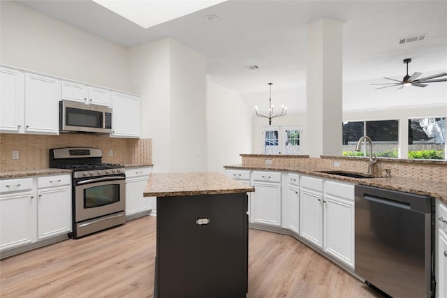 1202 Deergrove Dr, Cedar Park, TX 78613 - kitchen featuring appliances with stainless steel finishes, light wood-style floors, decorative backsplash, and vaulted ceiling
