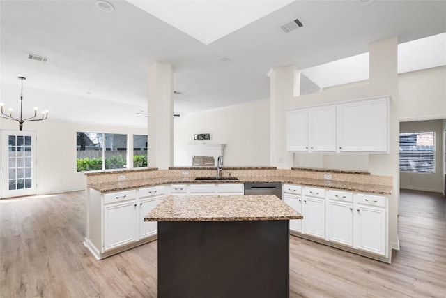 1202 Deergrove Dr, Cedar Park, TX 78613 - kitchen featuring a sink, a peninsula, a chandelier, light wood finished floors, and light stone counters
