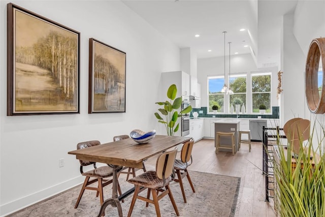 dining area featuring recessed lighting and light wood-style flooring
