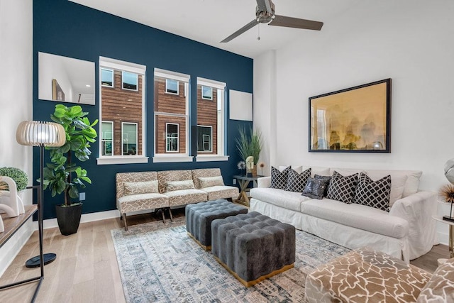 living area with wood finished floors, ceiling fan, and baseboards
