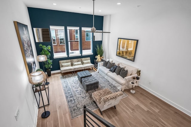 living room featuring wood finished floors, baseboards, recessed lighting, and a chandelier