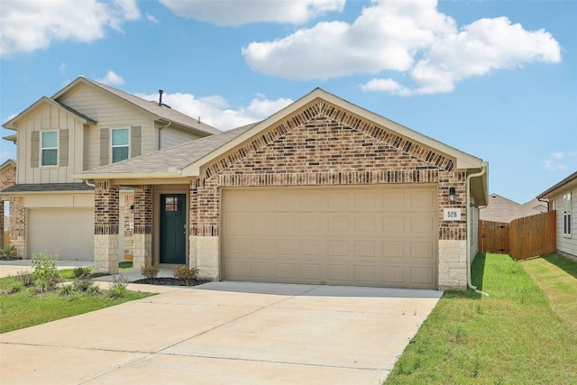 528 Evergreen Sumac Loop, Kyle, TX 78640 - view of front of home featuring stone siding, driveway, a garage, brick siding, and roof with shingles