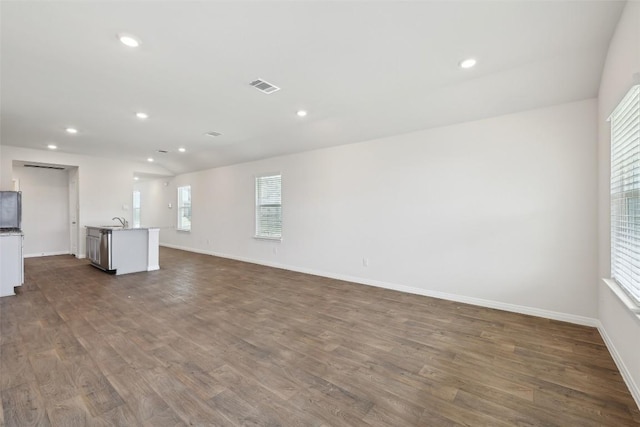 528 Evergreen Sumac Loop, Kyle, TX 78640 - unfurnished living room with dark wood-style floors, baseboards, recessed lighting, and a sink