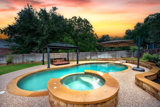 18004 Rosebud Pl, Round Rock, TX 78681 - pool at dusk with a gazebo, an in-ground hot tub, and a fenced backyard