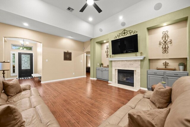 18004 Rosebud Pl, Round Rock, TX 78681 - living room featuring ceiling fan, wood finished floors, arched walkways, a high end fireplace, and recessed lighting