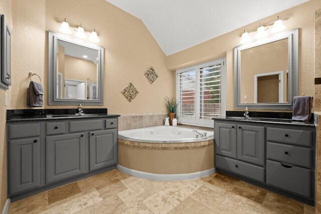 18004 Rosebud Pl, Round Rock, TX 78681 - bathroom featuring vaulted ceiling, two vanities, and a garden tub