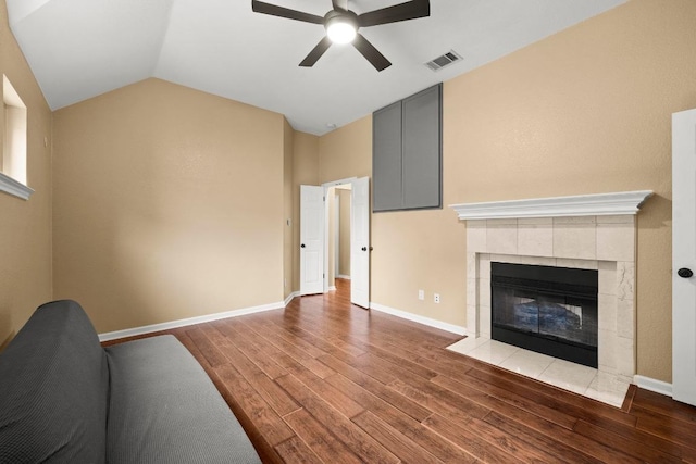 18004 Rosebud Pl, Round Rock, TX 78681 - living area featuring ceiling fan, wood finished floors, a tiled fireplace, vaulted ceiling, and baseboards