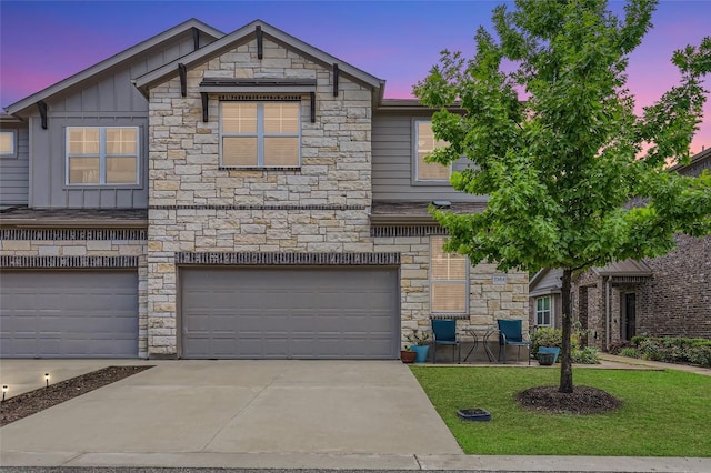 17301 Leafroller Dr Unit A, Pflugerville, TX 78660 - view of front of house with stone siding, board and batten siding, concrete driveway, an attached garage, and a yard