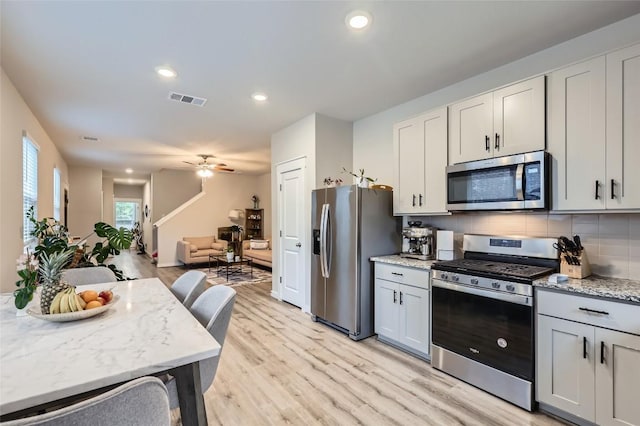 17301 Leafroller Dr Unit A, Pflugerville, TX 78660 - kitchen featuring appliances with stainless steel finishes, light wood-type flooring, decorative backsplash, open floor plan, and recessed lighting