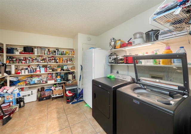 1810 Summer Rain Dr, Cedar Park, TX 78613 - clothes washing area featuring washing machine and clothes dryer, light tile patterned flooring, and a textured ceiling