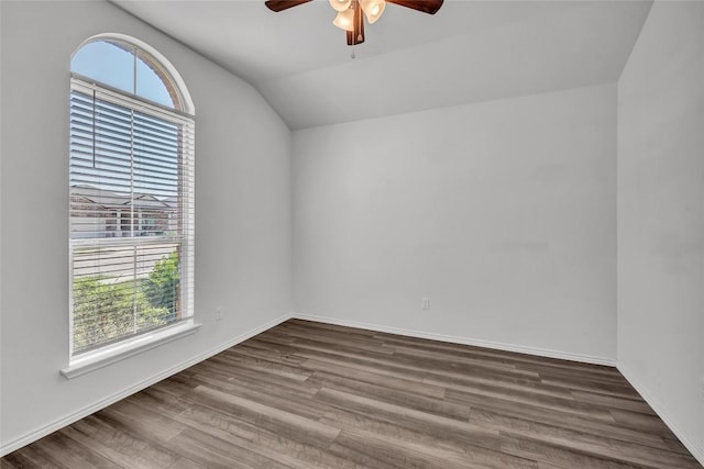 unfurnished room featuring healthy amount of natural light, a ceiling fan, vaulted ceiling, and wood finished floors