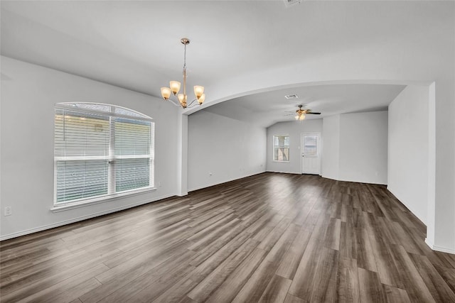 spare room featuring ceiling fan, dark wood-type flooring, a chandelier, and arched walkways