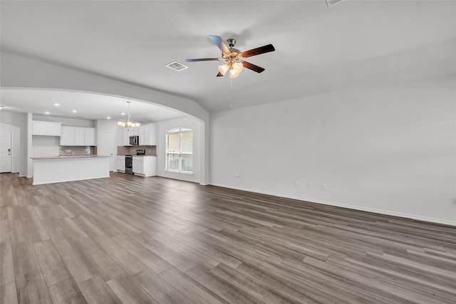 unfurnished living room with dark wood finished floors, ceiling fan, recessed lighting, arched walkways, and baseboards