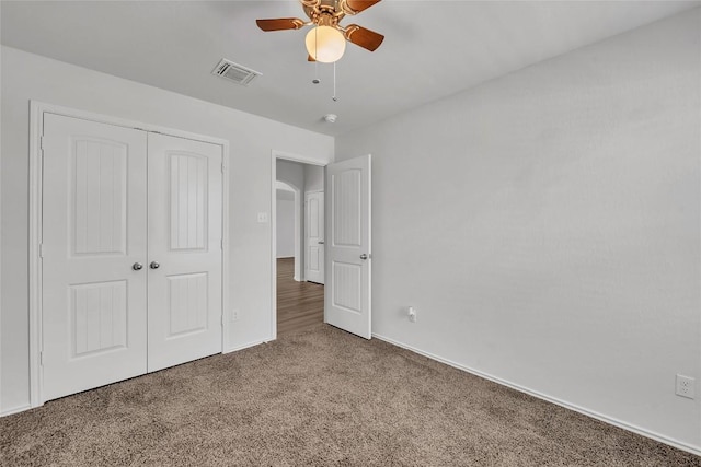 unfurnished bedroom with carpet, a closet, baseboards, and a ceiling fan