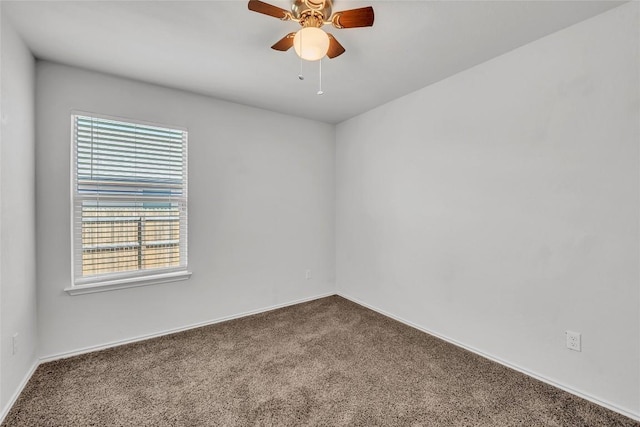 empty room featuring dark carpet, healthy amount of natural light, a ceiling fan, and baseboards
