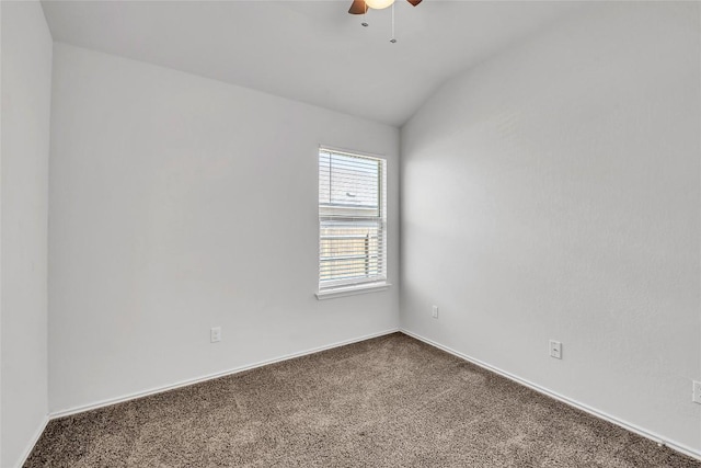 empty room featuring dark carpet, lofted ceiling, ceiling fan, and baseboards