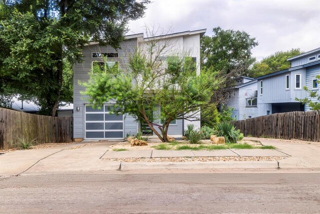 1314 Delano St Unit A, Austin, TX 78721 - view of front facade featuring fence, driveway, and a garage