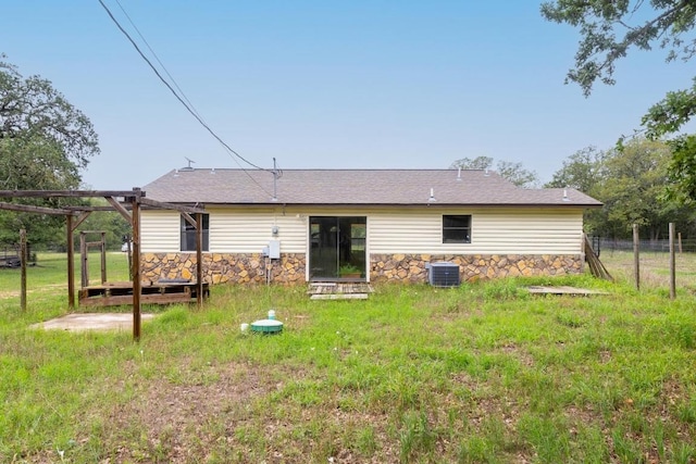 326 Zapalac Rd, Smithville, TX 78957 - back of house featuring central AC, stone siding, fence, and roof with shingles
