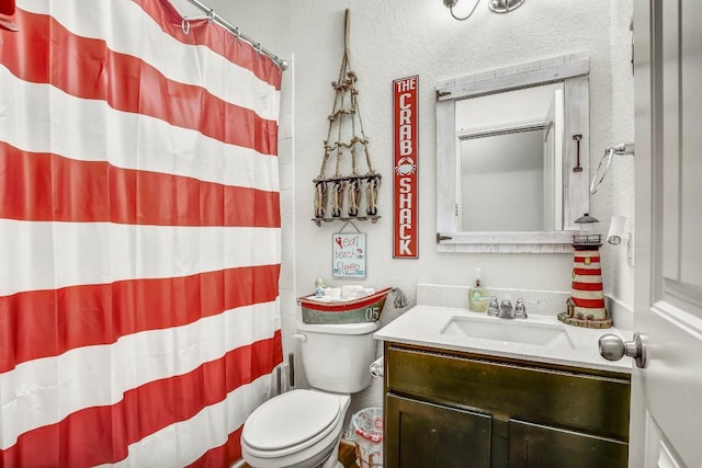 bathroom with vanity, toilet, a shower with curtain, and a textured wall