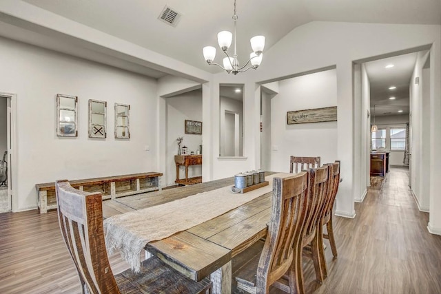 dining space with wood finished floors, a chandelier, vaulted ceiling, recessed lighting, and baseboards