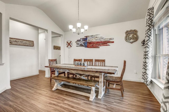 dining area featuring a chandelier, wood finished floors, and vaulted ceiling
