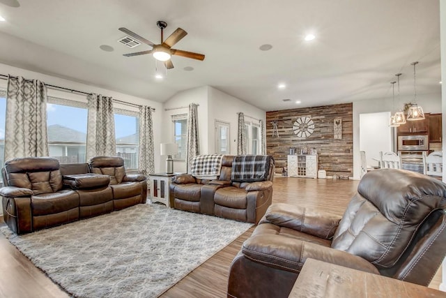 living room featuring a ceiling fan, wood finished floors, recessed lighting, and wood walls