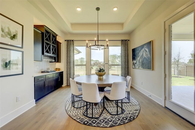 105 Isaac White Dr, Bastrop, TX 78602 - dining area featuring a chandelier, healthy amount of natural light, a tray ceiling, bar area, and recessed lighting