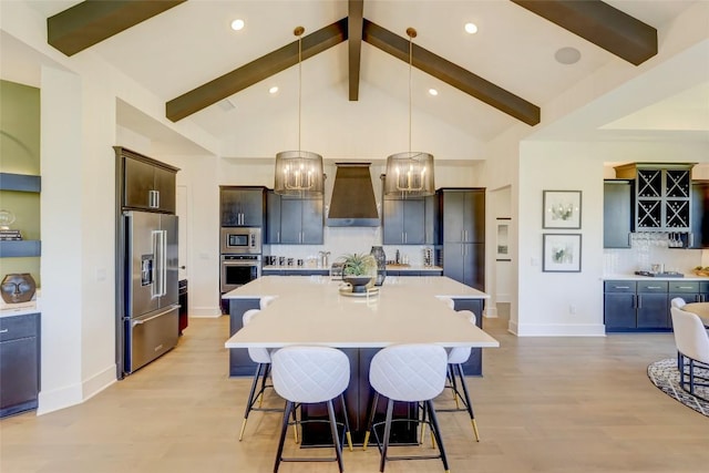105 Isaac White Dr, Bastrop, TX 78602 - kitchen with stainless steel appliances, wall chimney range hood, light countertops, a large island, and a breakfast bar