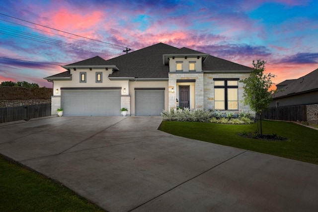 147 Epoch Dr, Austin, TX 78737 - view of front of home with stucco siding, driveway, stone siding, an attached garage, and roof with shingles