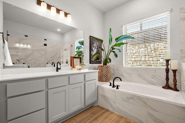 147 Epoch Dr, Austin, TX 78737 - bathroom with a stall shower, a garden tub, vanity, and wood finished floors