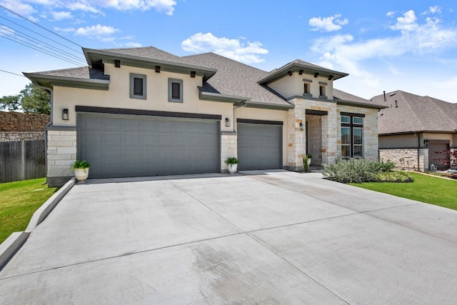 147 Epoch Dr, Austin, TX 78737 - view of front of home with stucco siding, an attached garage, stone siding, and concrete driveway