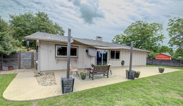 10500 Berthound Dr, Austin, TX 78758 - back of property with board and batten siding, a patio area, a fenced backyard, a chimney, and roof with shingles