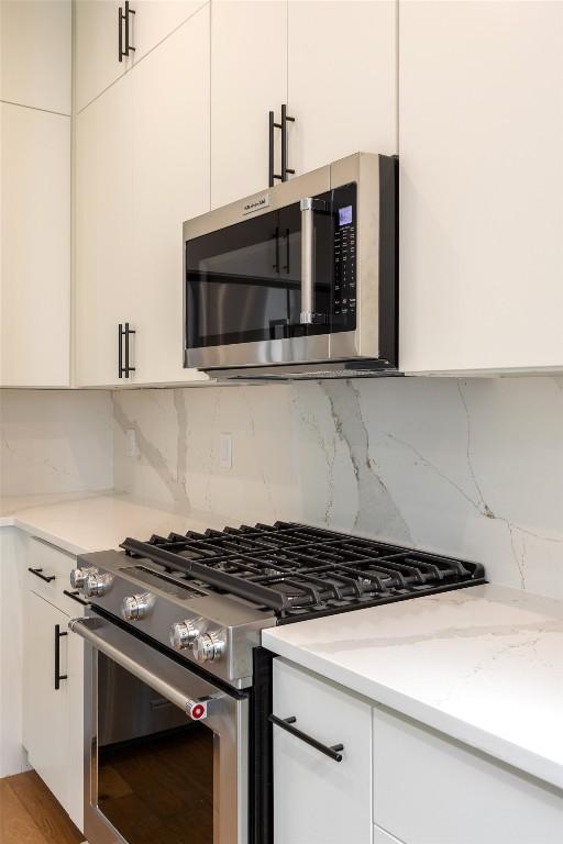 3208 Clawson Rd Unit 2, Austin, TX 78704 - kitchen featuring stainless steel appliances, backsplash, and white cabinets
