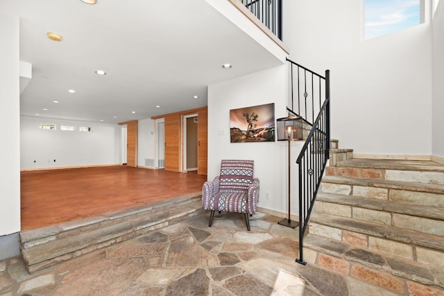 foyer entrance featuring recessed lighting, stone finish flooring, stairs, and baseboards