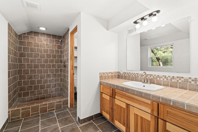 13821 Hunters Pass, Austin, TX 78734 - full bath with vanity, tiled shower, and decorative backsplash