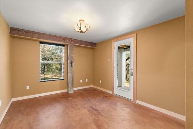 unfurnished room featuring concrete floors and baseboards