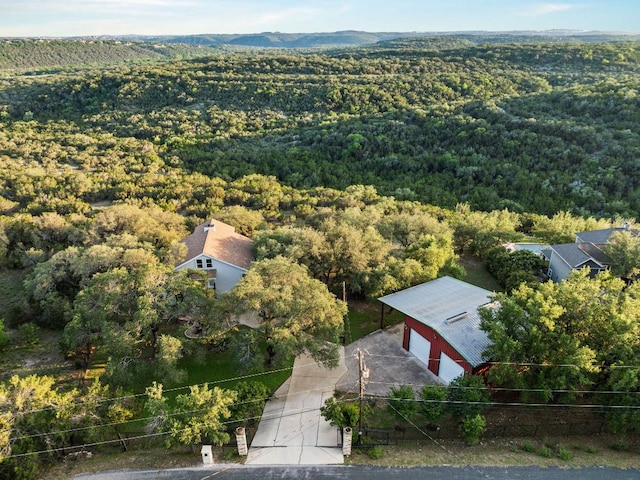 aerial view of property and surrounding area featuring a heavily wooded area