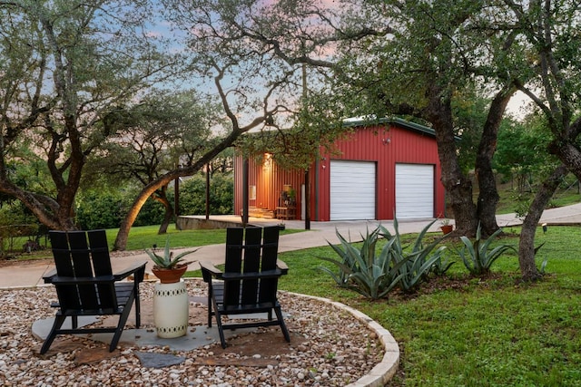 view of green lawn featuring a garage and an outdoor structure