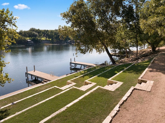 dock area with a water view and a lawn