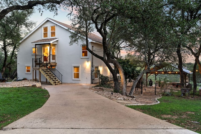 view of front of house featuring stairs, driveway, and stucco siding