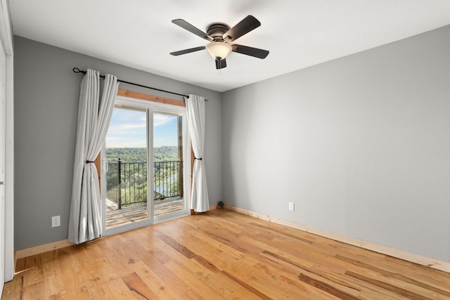 spare room with light wood-style floors, a ceiling fan, and baseboards