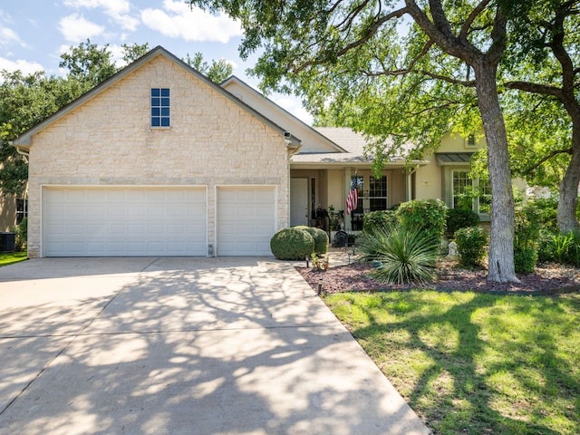 101 Chickadee Cv, Georgetown, TX 78633 - view of front of house featuring stone siding, driveway, an attached garage, a front lawn, and stucco siding