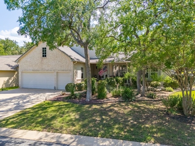 101 Chickadee Cv, Georgetown, TX 78633 - view of property hidden behind natural elements with stone siding, driveway, a garage, and a front yard