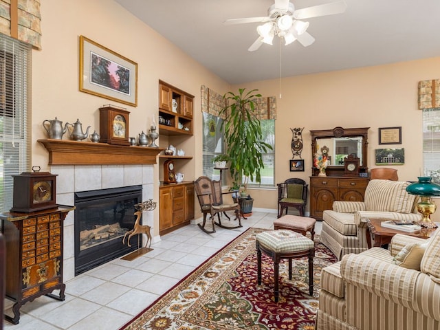 101 Chickadee Cv, Georgetown, TX 78633 - living area with light tile patterned floors, ceiling fan, a tiled fireplace, and baseboards