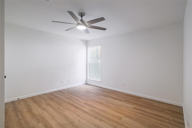 spare room featuring light wood-style flooring, baseboards, and ceiling fan